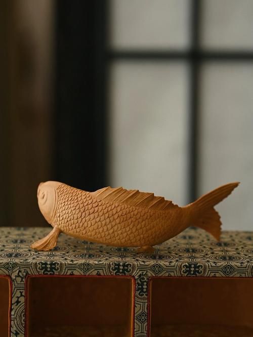 給我一些木雕魚的圖片，木雕魚不僅是中國傳統雕刻藝術的重要組成部分，更是木雕魚
